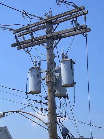 utility pole: a tall cylinder, often made from the trunk of a tree, usually topped by a cross beam, used by a...