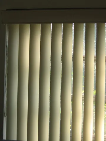 vertical blinds: a series of thin slats that hang in front of a window, which can be turned as a group close with a...