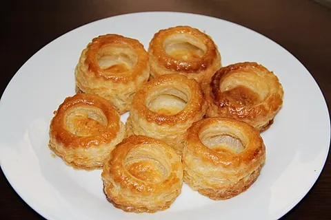 vol-au-vent: a small circular piece of puff pastry with a hole for various fillings, such as mushrooms, prawns,...