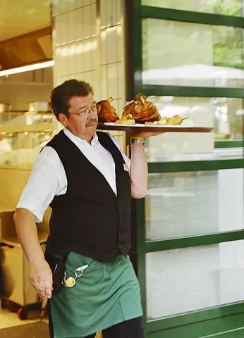 waiter: a male or female attendant who serves customers at their tables in a restaurant, café or similar