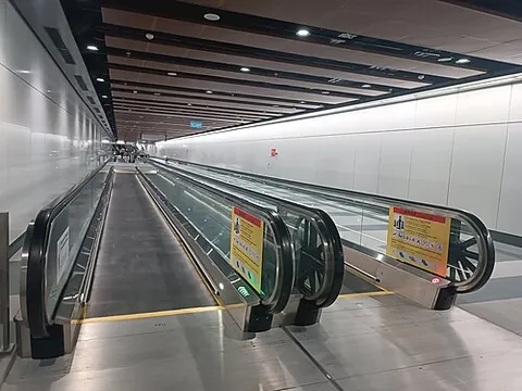 walkalator: a moving walkway (a slow conveyor belt that transports people horizontally or on an incline in a...