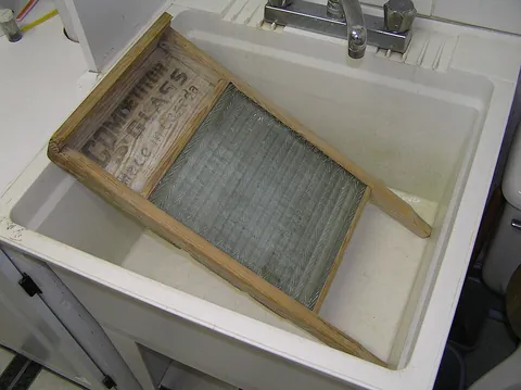washboard: a board with a corrugated surface against which laundry may be rubbed