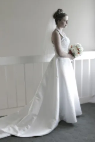 wedding dress: the dress worn by a bride during a wedding ceremony, traditionally white with a long train in...