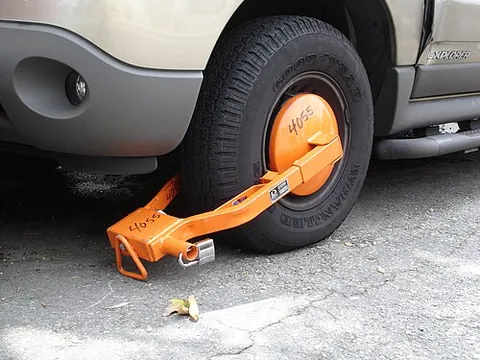 wheel clamp: a device locked to the wheel of a motor car to prevent it from being driven; normally used to...