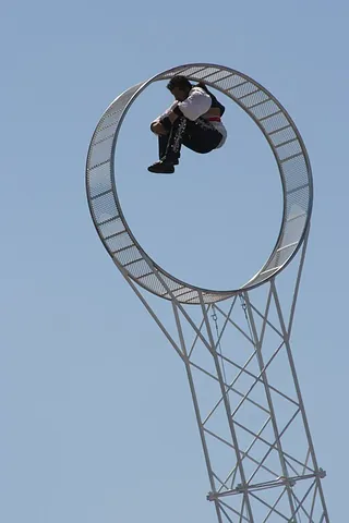 wheel of death: a hollow wheel larger than a person, attached to and suspended from an axle, and inside of which an...