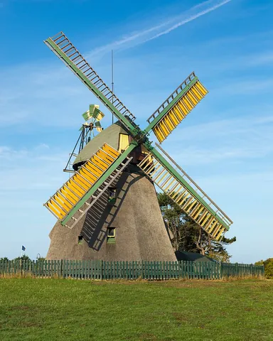 windmill: a machine which translates linear motion of wind to rotational motion by means of adjustable vanes...