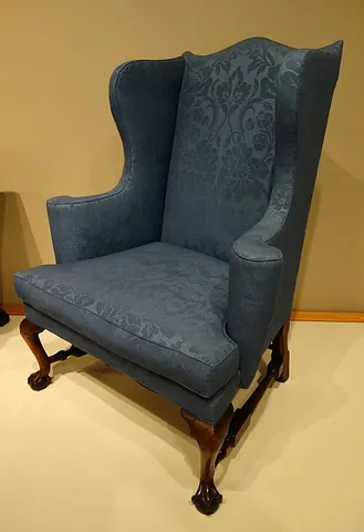 wing chair: a chair with a high back from which project small side pieces, originally to protect from draught