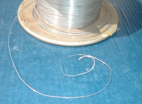 wire: metal formed into a thin, even thread, now usually by being drawn through a hole in a steel die