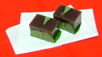 yokan: a thick jellied dessert made of red bean paste, agar, and sugar, usually sold in block form and...