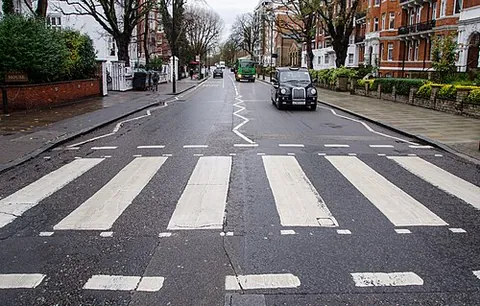 zebra crossing: a pedestrian crossing featuring broad white stripes painted parallel to the street
