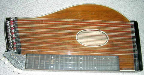 zither: a musical instrument consisting of a flat sounding box with numerous strings placed on a horizontal...