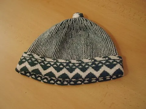 zmijovka: a traditional Czech knitted wool cap with no bill, topped by a small pom-pom, and encircled with a...