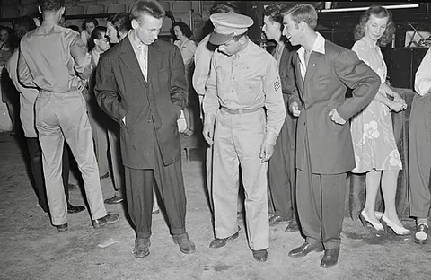 zoot suit: an outfit featuring a suit with broad shoulders, a long coat, and baggy trousers that taper to a...